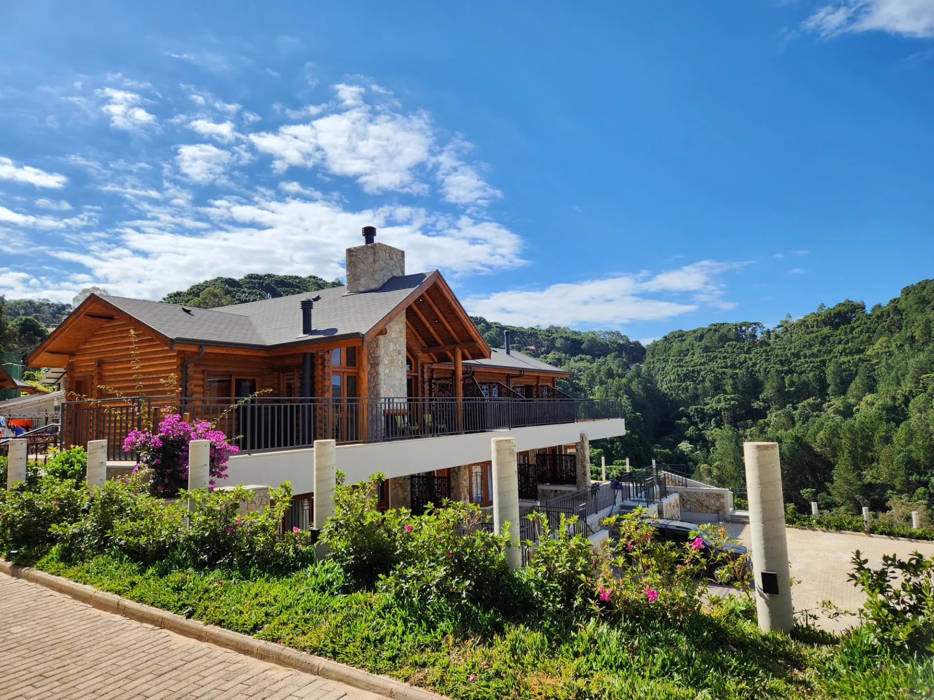 Fachada em madeira da Pousada Maple em Monte Verde MG cercada pelas montanhas da Mantiqueira